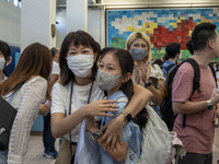 A parent hugs her girl after hearing the result of her Secondary School Allocation Result at a school hall on July 11, 2023 in Hong Kong, Ch...