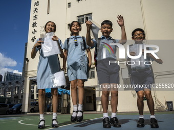 Students holding their secondary school allocation result jumping in the air while posing for a photo on July 11, 2023 in Hong Kong, China....