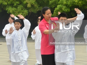 

A coach is instructing students to practice Tai Chi in Handan, Hebei Province, China, on July 13, 2023. (