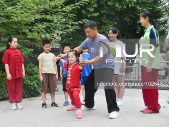 

A coach is instructing a child to practice Tai Chi in Handan, Hebei Province, China, on July 13, 2023. (