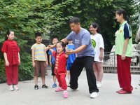 

A coach is instructing a child to practice Tai Chi in Handan, Hebei Province, China, on July 13, 2023. (