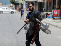 A young man carries fans amid a heat wave at Shati refugee camp in Gaza City, July 26, 2023. 
 (