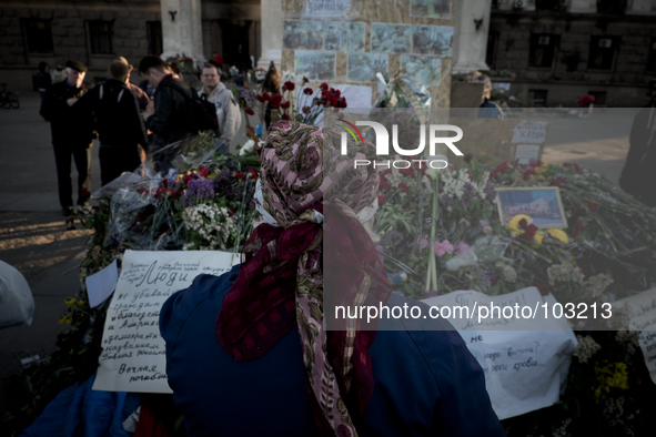 A woman mourns in front of flowers outside the burnt trade union building in Odessa, Ukraine, Wednesday May 7, 2014. More than 40 people die...