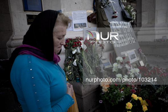 A woman mourns in front of flowers outside the burnt trade union building in Odessa, Ukraine, Wednesday May 7, 2014. More than 40 people die...