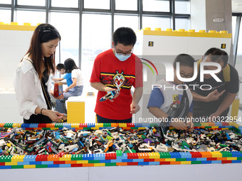 Citizens experience assembling Lego at Changle Digital Education Town 101 Art Tide Play Center in Fuzhou, Fujian province, China, July 30, 2...