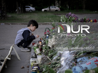 A boy list up a candle outside the burnt trade union building in Odessa, Ukraine, Wednesday May 7, 2014. More than 40 people died in the rio...