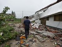A citizen passes a damaged house after a tornado in Dafeng district, Yancheng city, Jiangsu province, China, August 14, 2023. It is understo...