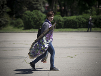 Ukraine, Odessa : A unidentified woman carries flowers outside the burnt trade union building in Odessa, Ukraine, May 8, 2014. More than 40...