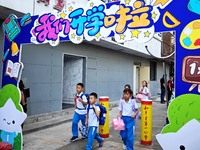 Children walk into a primary school in Beijing, China, September 1, 2023. On the same day, the new semester of primary and secondary schools...