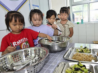 Students receive cutlery for lunch at Yanghe Primary School in Gaoliu town, Qingzhou city, East China's Shandong province, Sept 4, 2023. (
