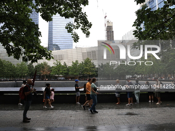 Visitors gather to pay tribute to the victims of 9/11 attacks near one of two reflecting pools at the National September 11 Memorial & Museu...
