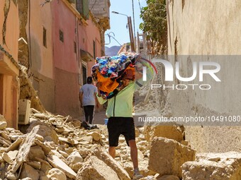 A young man in the village of Amizmiz is retrieving blankets from his home amid the rubble. (