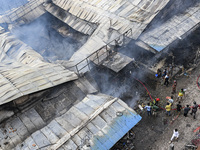 Firefighters and local people try to extinguish a fire that broke out, at the Mohammadpur Krishi Market in Dhaka, Bangladesh, on September 1...