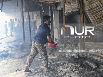 A shop owner tries to extinguish a fire that broke out, at the Mohammadpur Krishi Market in Dhaka, Bangladesh, on September 14, 2023.
 (