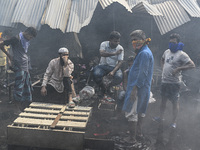 Shop owners gather in front of their shop after a massive fire broke out, at the Mohammadpur Krishi Market in Dhaka, Bangladesh, on Septembe...