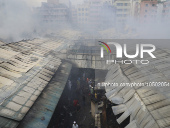 
Firefighters and volunteers are seen at the Mohammadpur Krishi Market, while smoke rises after a massive fire broke out, in Dhaka, Banglad...