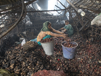 Shopkeepers look for the goods that survived from the massive fire at Mohammadpur Krishi Market in Dhaka on September 14, 2023. A massive bl...
