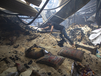 Shopkeepers look for the goods that survived from the massive fire at Mohammadpur Krishi Market in Dhaka on September 14, 2023. A massive bl...
