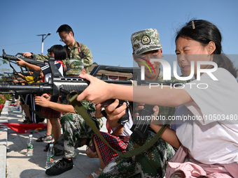 Children experience militia weapons and equipment at a new recruit training camp in Tianjia town, Neijiang city, Sichuan province, China, Se...