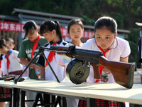 Children inspect militia weapons and equipment at a new recruit training camp in Tianjia town, Neijiang city, Sichuan province, China, Septe...