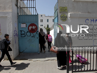 Children enter a school building as the 2023-2024 academic year begins for Tunisian students after the summer holiday in Tunis, Tunisia on S...