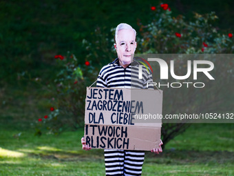 A protestor wearing a mask with Jaroslaw Kaczynski's face and holdind a banner reading 'I am a threat for you and your close ones' during an...