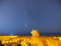The Milky Way galaxy appears in the sky above the shipwreck of Torre San Giovanni, Puglia, Italy, on October 4, 2023. The fishing vessel dri...