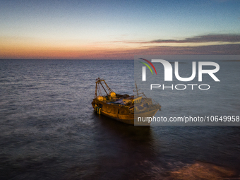 A drone view of the wreck of Torre San Giovanni at sunset, on October 15, 2023. The fishing vessel drifted towards the shores of Torre San G...