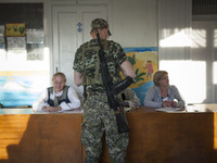 A militiaman from the People's Republic of Donetsk self defence forces registers before voting at a polling station in Kramatorsk, eastern U...