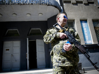 UKRAINE, Slavyansk :  An armed man in front of a voting booth during the referendum called by pro-Russian rebels in eastern Ukraine to split...