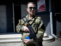 UKRAINE, Slavyansk :  An armed man in front of a voting booth during the referendum called by pro-Russian rebels in eastern Ukraine to split...