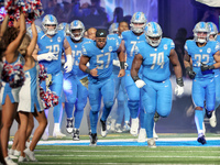 Detroit Lions players run onto the field ahead of an NFL  football game between the Detroit Lions and the Chicago Bears in Detroit, Michigan...