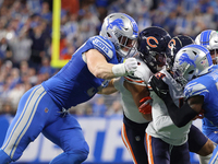 Chicago Bears wide receiver DJ Moore (2) is tackled by Detroit Lions defensive end Aidan Hutchinson (97) during the first half of an NFL foo...