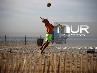 A person plays volleyball on the beach in Santa Monica, United States on November 13, 2023. (