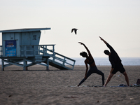 People exercise on the beach in Santa Monica, United States on November 13, 2023. (