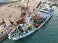 YANTAI, CHINA - NOVEMBER 21, 2023 - At Longkou Port in Shandong province, a crane loads a navigation mark onto the ''Haixun 153'' navigation...