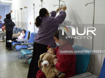Sick children, accompanied by their parents, are waiting for treatment at the Department of Pediatrics of the People's Hospital in Fuyang Ci...