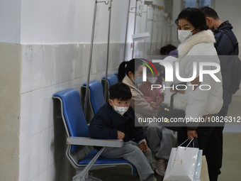 Sick children, accompanied by their parents, are waiting for treatment at the Department of Pediatrics of the People's Hospital in Fuyang Ci...