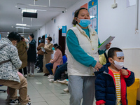Parents and children with respiratory infectious diseases are waiting to see a doctor at the Children's Hospital in Chongqing, China, on Dec...