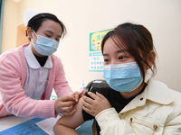 A medical worker is inoculating a citizen against influenza at a community health service center in Guiyang, Guizhou Province, China, on Dec...