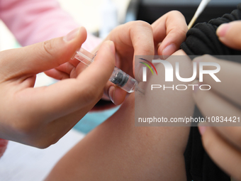 A medical worker is inoculating a citizen against influenza at a community health service center in Guiyang, Guizhou Province, China, on Dec...