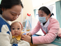 A medical worker is giving a child a flu vaccine at a community health service center in Guiyang, Guizhou Province, China, on December 7, 20...