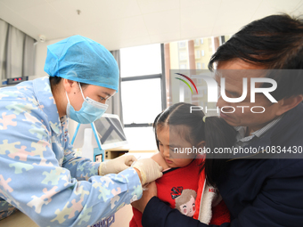 A medical worker is giving a child a flu vaccine at a community health service center in Guiyang, Guizhou Province, China, on December 7, 20...