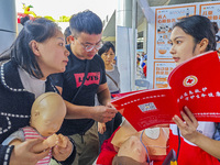 Participants are practicing cardiopulmonary resuscitation (CPR) at the 2023 China-ASEAN Health Industry Summit in Nanning, Guangxi, China, o...