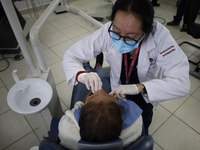 A dentist at the Centro de Salud TIII Doctor Guillermo Roman y Carrillo in the Iztapalapa district of Mexico City is attending to an older a...