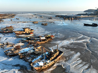 Fishing boats are being frozen by ice at the seaside of the Lianyun district in Lianyungang, East China's Jiangsu province, on December 21,...