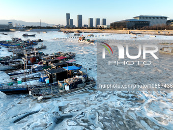 Fishing boats are being frozen by ice at the seaside of the Lianyun district in Lianyungang, East China's Jiangsu province, on December 21,...