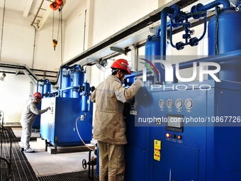A staff member is inspecting the operation of equipment in a heating workshop at a thermal power company in Nantong, Jiangsu province, China...