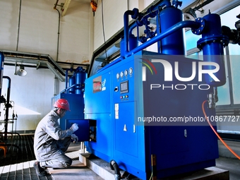 A staff member is inspecting the operation of equipment in a heating workshop at a thermal power company in Nantong, Jiangsu province, China...