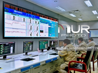 Workers are monitoring heating operations at the main control center of a thermal power company in Nantong, Jiangsu province, China, on Dece...